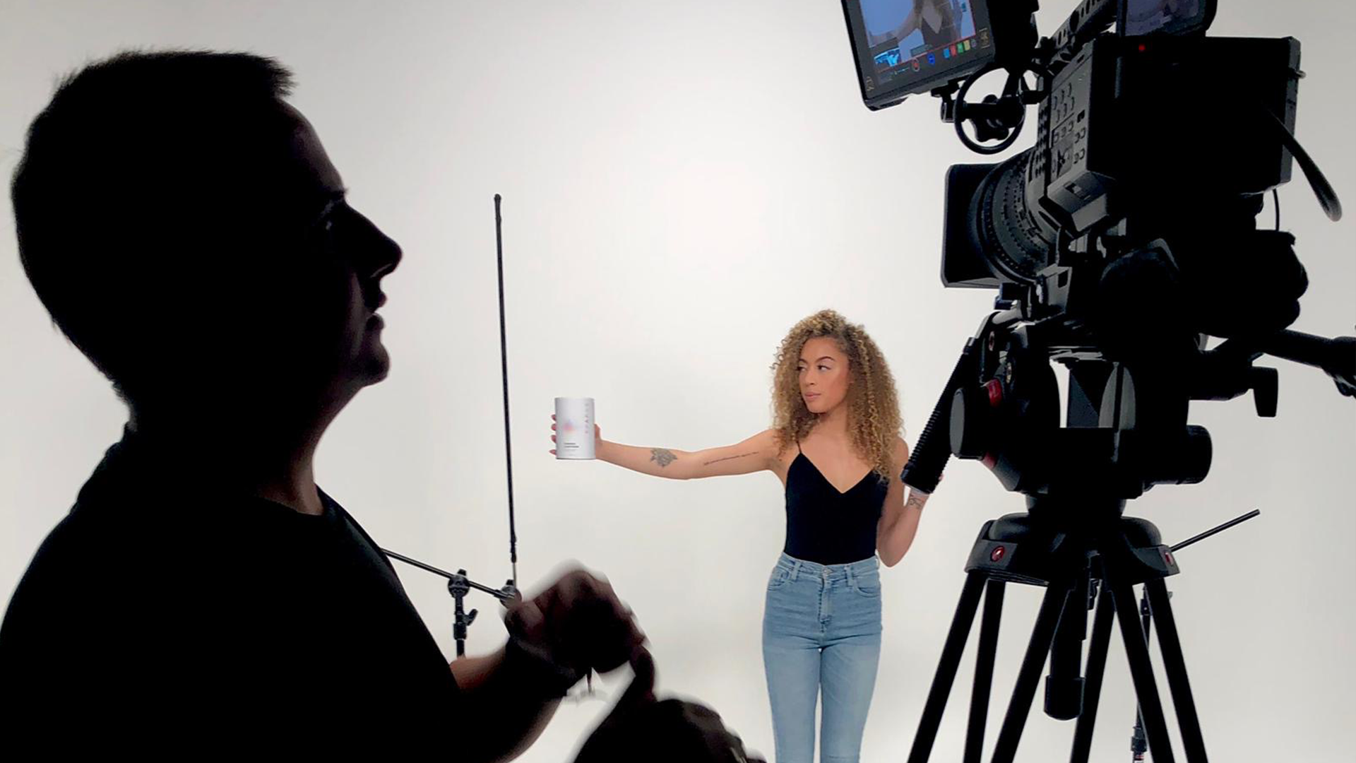 camera man silhouette and girl in front of white screen